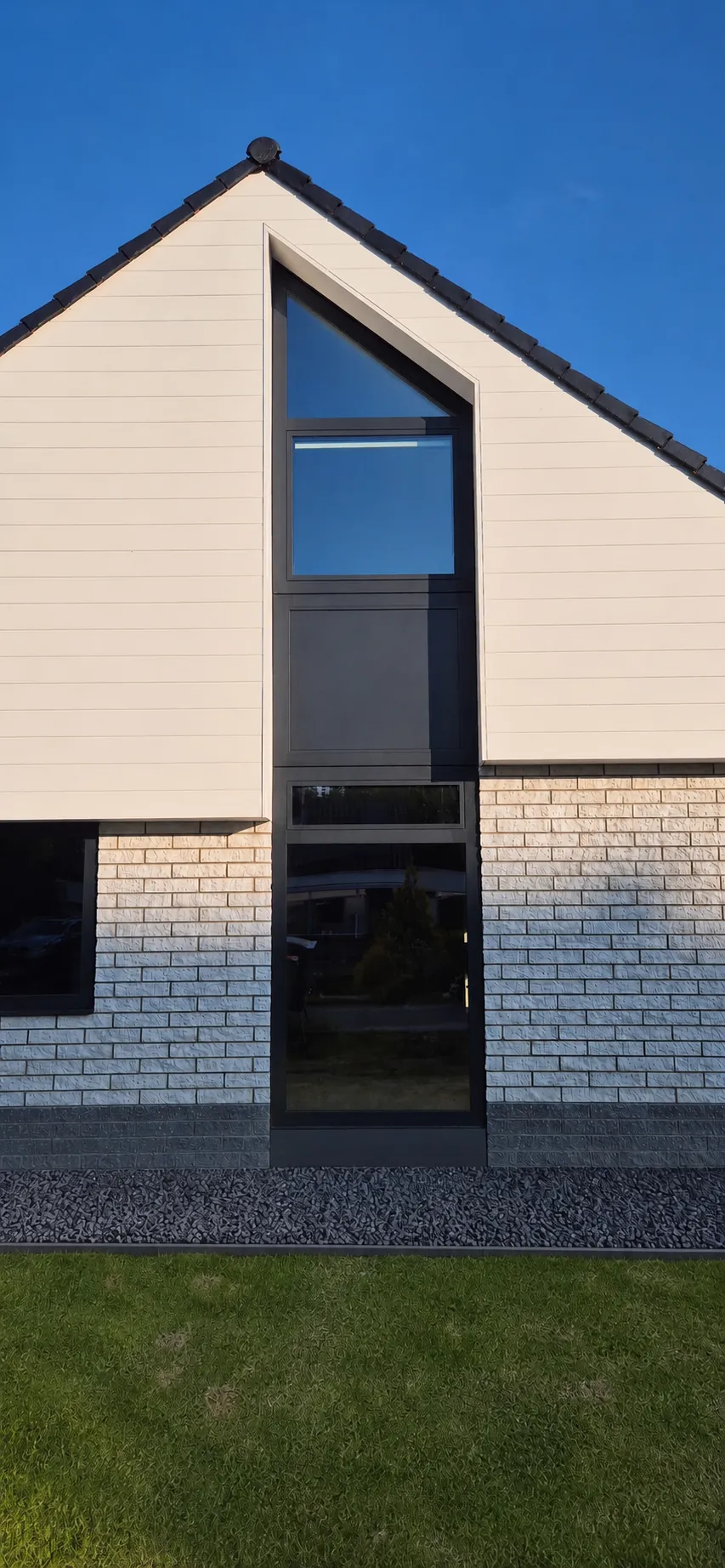 Nieuwbouwwoning in Uithuizermeeden met een zwart kunststof kozijn en een driekantkozijn in de puntgevel
